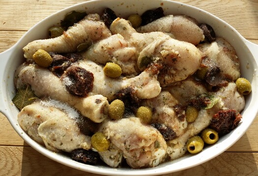 Куриные голени с оливками и черносливом перед запеканием в духовке